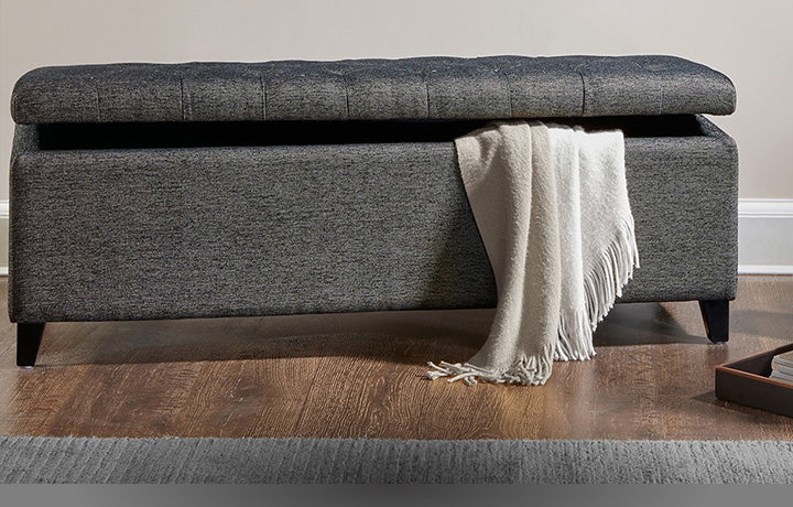 Gray storage bench with a white throw blanket