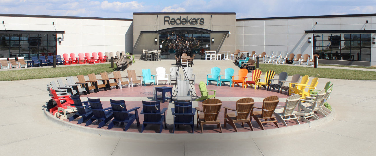 Outdoor display of colorful Adirondack chairs at Redekers